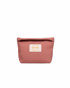 Pink toiletry bag with a brand label on a white background