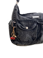 Black denim handbag with cherry charm on a white background