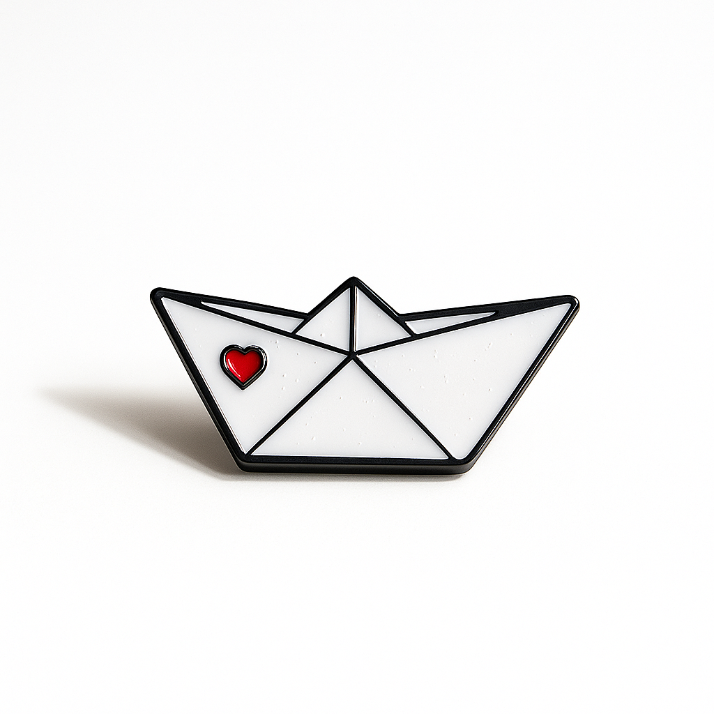 Pin with a design of a paper boat with a red heart on a white background